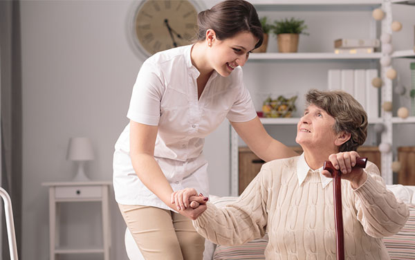 Nurse assisting elderly woman.