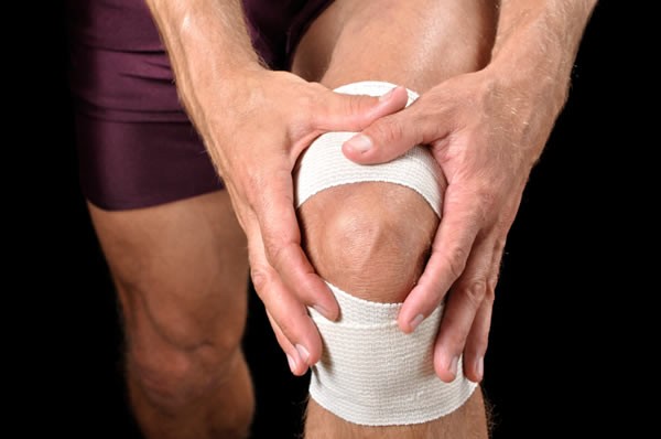 Sportsman holding bandaged knee