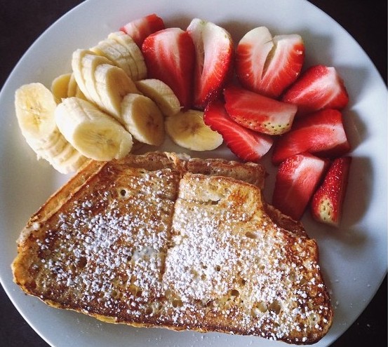 French toast on plate with banana and strawberries