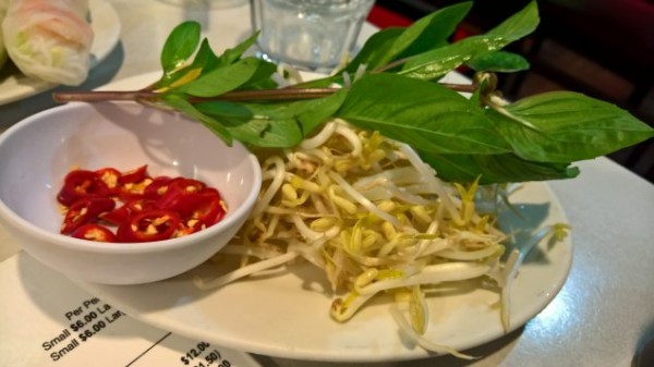 A plate of Thai basil, mung bean shoots and chopped chillies