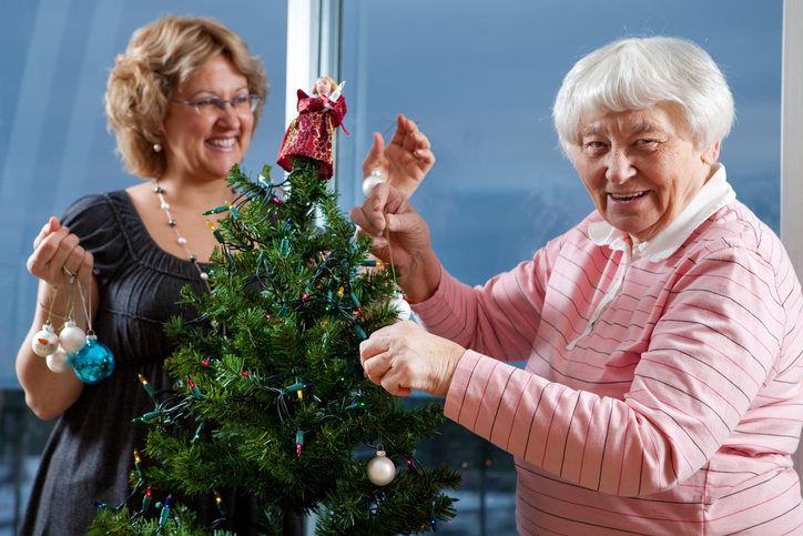 Volunteer helping senior decorate her Christmas Tree. Photo: iStock