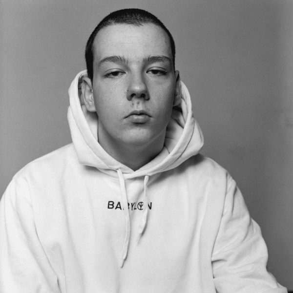 Black and white photo of young man wearing a white hoodie