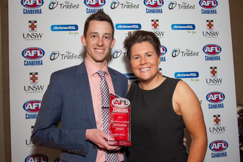 man holding an award and a woman