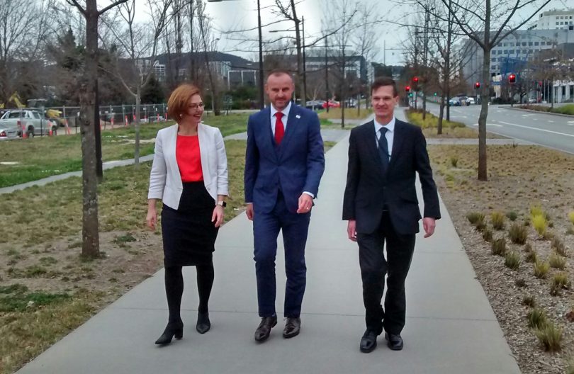 woman and two men in street