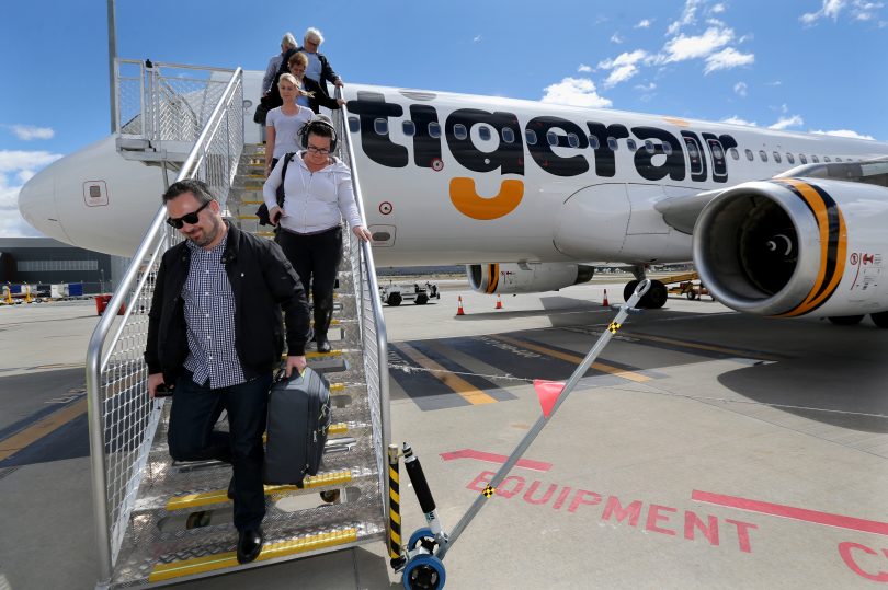 Passengers disembark from plane