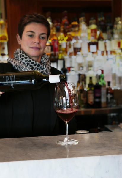 woman pouring red wine into wine glass 