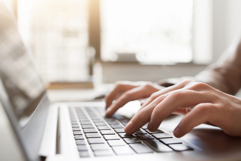 Hands on a laptop keyboard