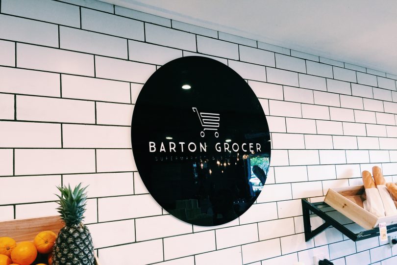 Black and White Barton Grocer sign hanging on the wall