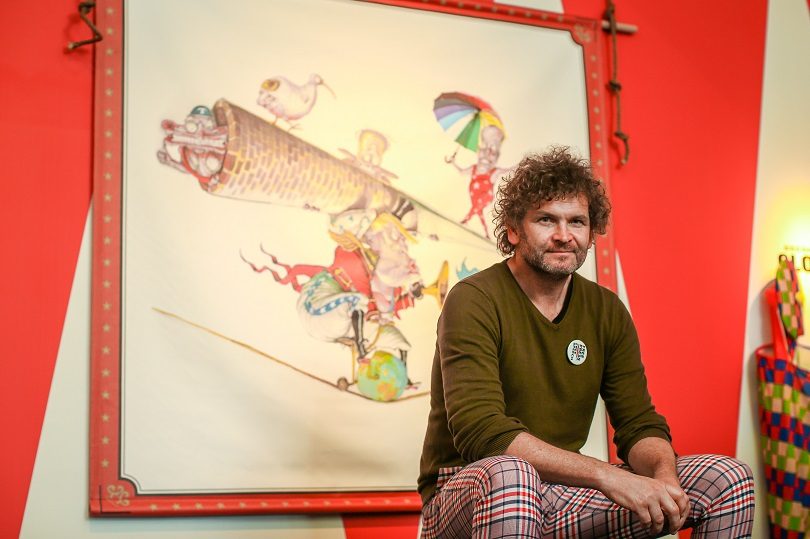 David Rowe seated in front of his beautiful "Hero Cartoon" at the launch of Behind the Lines 2017. Photo: Mark Nolan, MoAD.