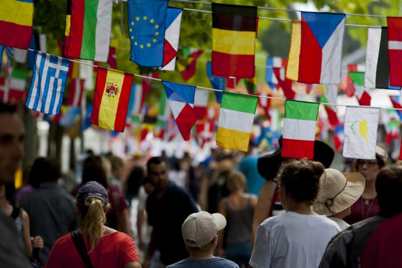 multicultural flags above people's heads.