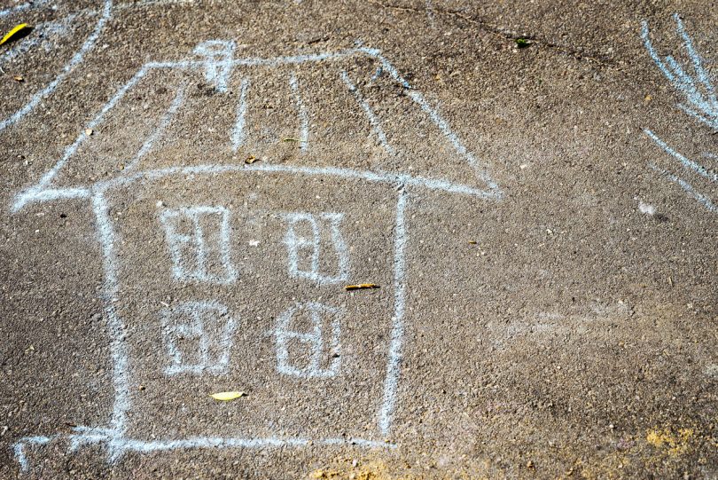 Chalk drawing of a house on cement