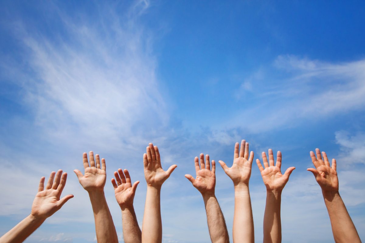 Hands reaching to the blue sky 