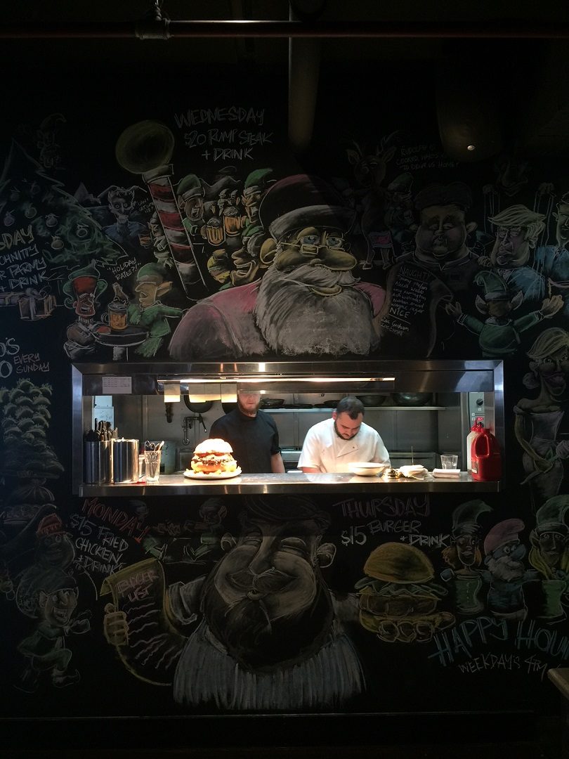 Shorty's Chef's working their craft, surrounded by the beautiful artwork that covers the kitchen wall! Photo: Elias Hallaj.