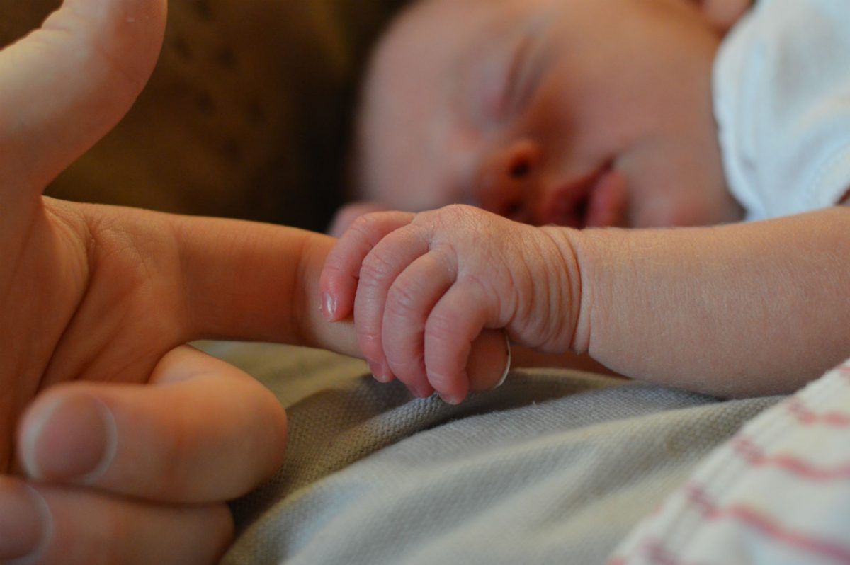 Baby holding mother's hand