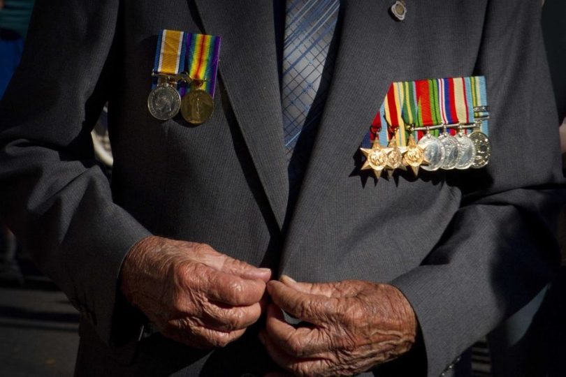 Elderly digger wearing suit with war medallions