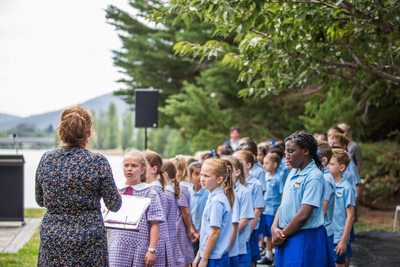 Schoolchildren sing <em>Give Peace a Chance</em> at the ceremony.