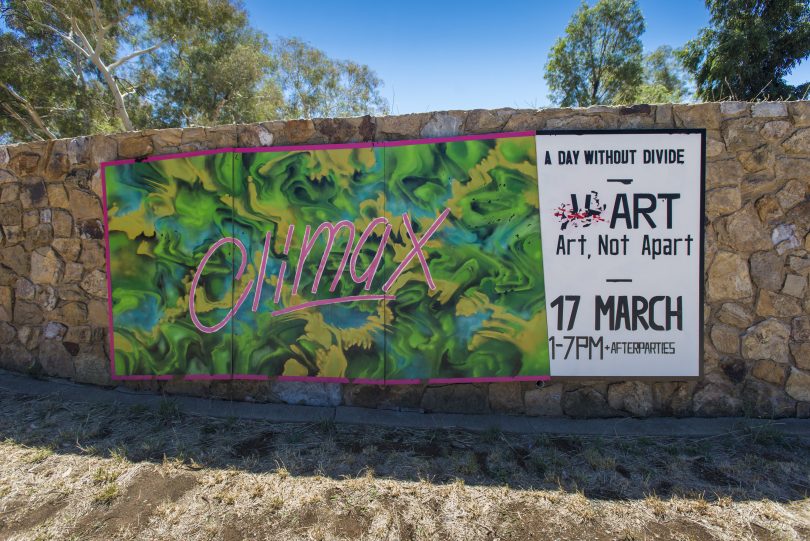 Painted sign on stone wall reads 'Climax', alongside Art, Not Apart poster. 