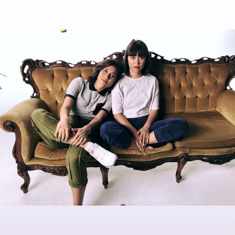 Photograph of two members of Haiku Hands on a couch