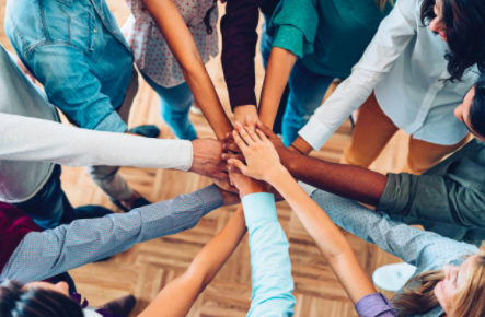 Hands of people from different races connecting together in a circle