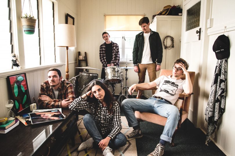 Five musicians in a sunroom 