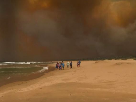 People seeking sanctuary on Tathra Beach as the flames of March 18 moved into the town. Photo: Simone Ward Facebook.