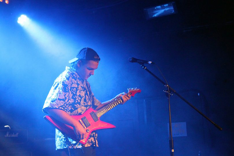 Photograph of The Chats band member playing 