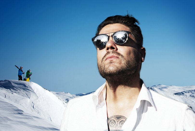 Photograph of Dan Sultan standing on a ski slope. 