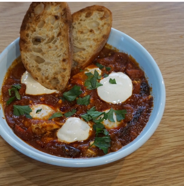 Spanish Shakshuka packed with cooked eggs in a tomato sugo with chorizo, feta &amp; red peppers with toasted sourdough and coriander yoghurt. Photo: Sophia Brady