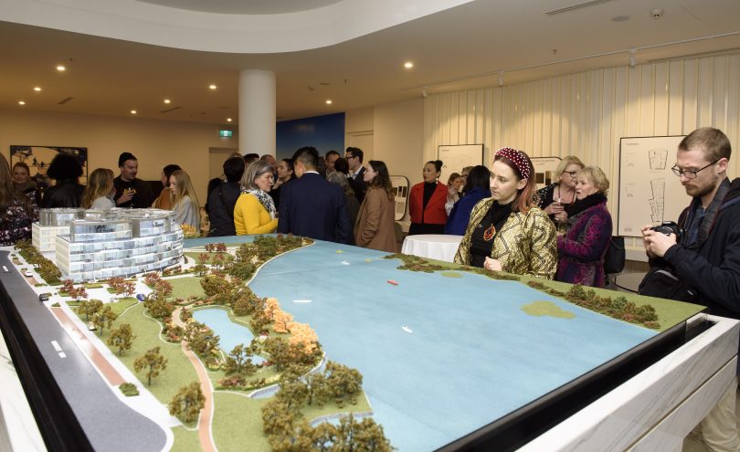 VIP guests admire the architectural model of Sapphire, with its curved form connecting it to the peninsula it overlooks