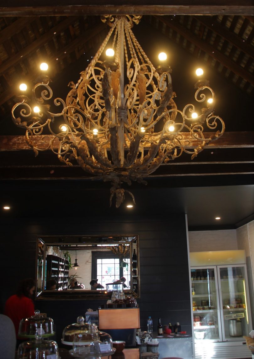 The massive iron chandelier suspended through the rafters.