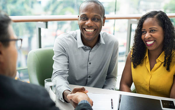 couple smiling shaking man's hand