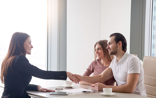 mortgage broker shaking hands with man and woman