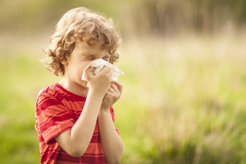 Young boy blowing his nose