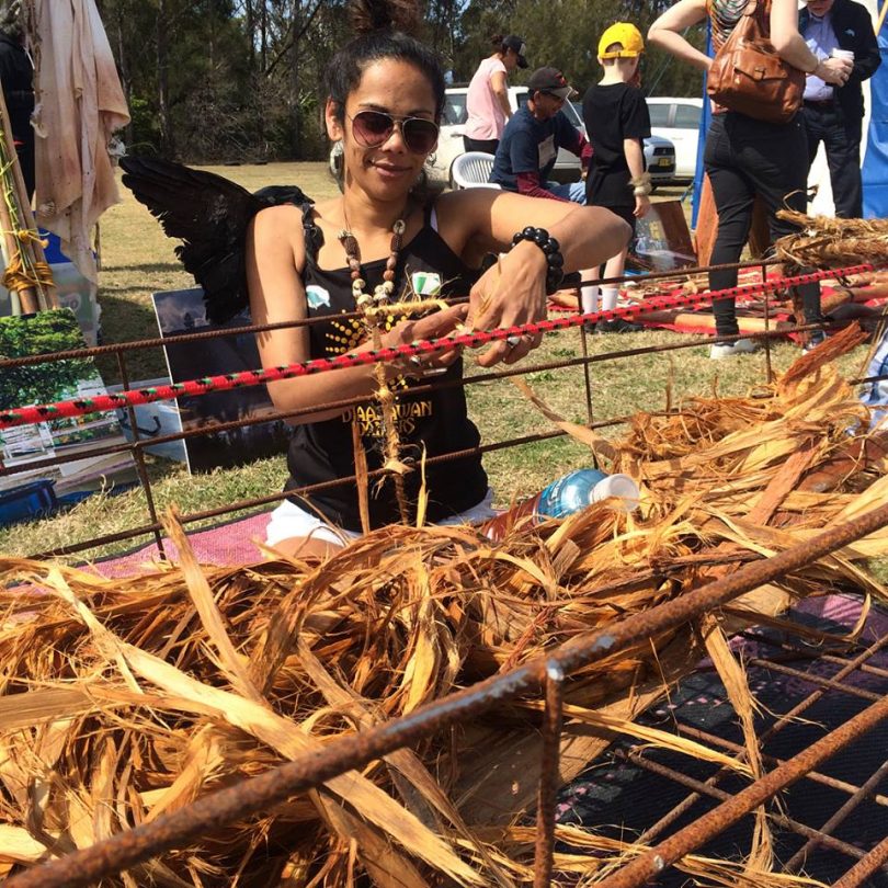 Narooma's Ashweeni Mason weaving stringy bark into a canoe sculpture. Photo: Giiyong Facebook.