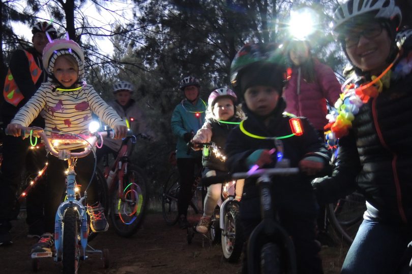 people on bikes with glowing lights