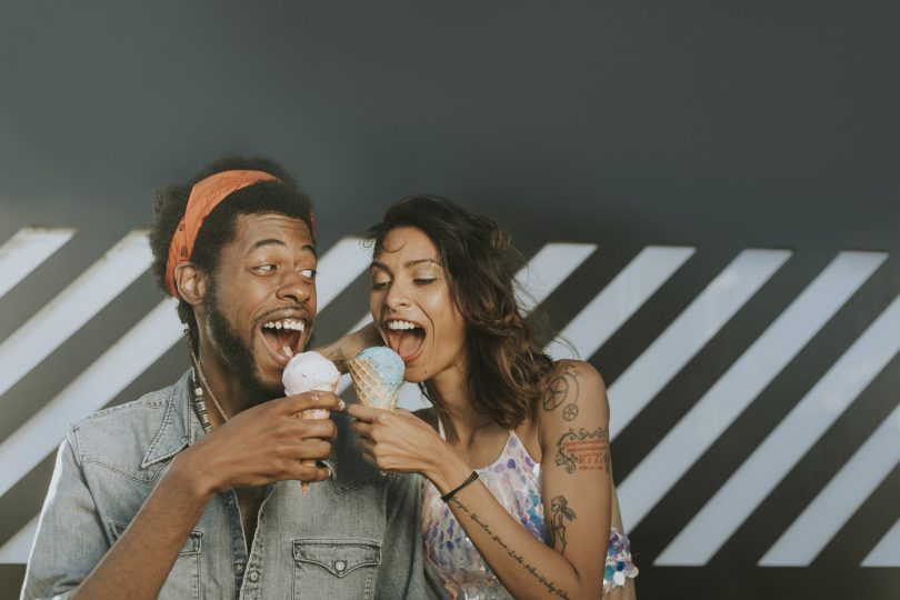 Man and woman smiling and eating ice cream together