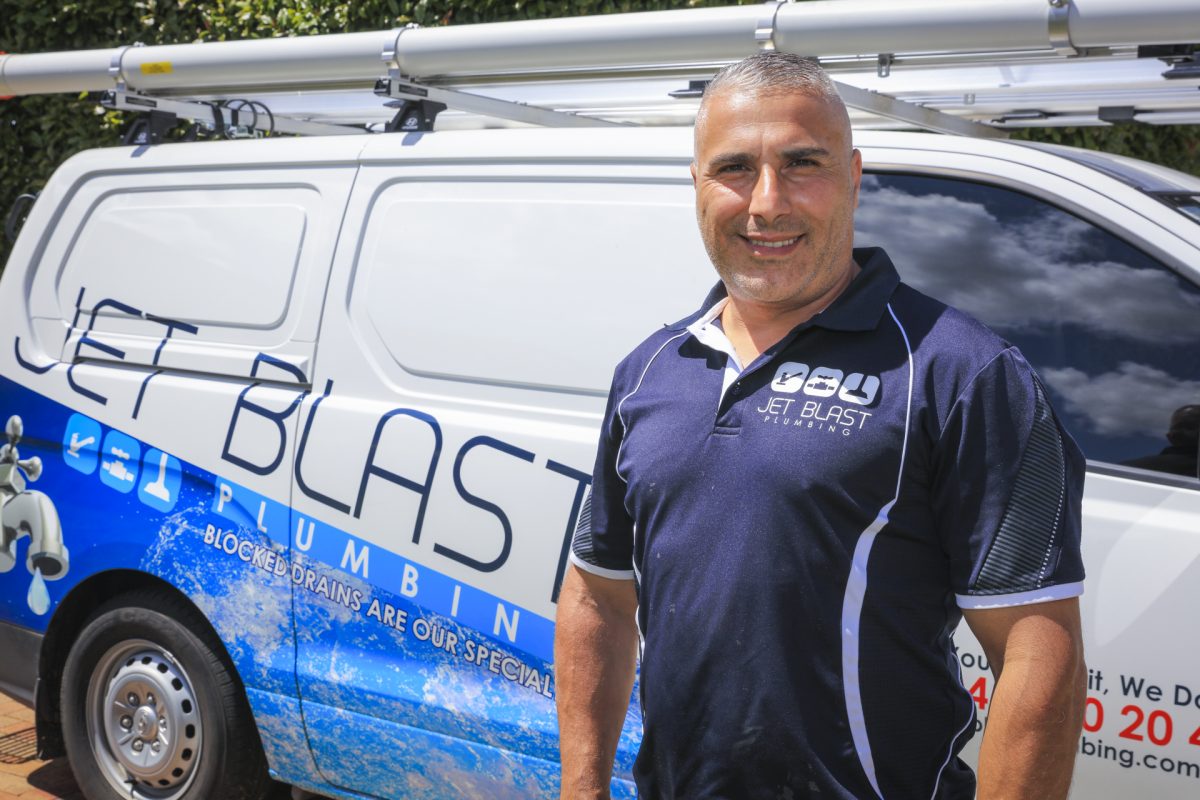 a man wearing uniform standing in front of a branded van