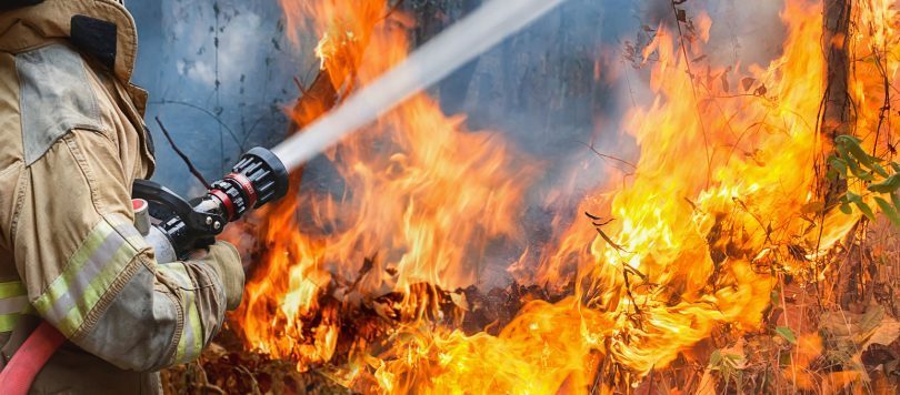 Firefighter fighting blaze with hose