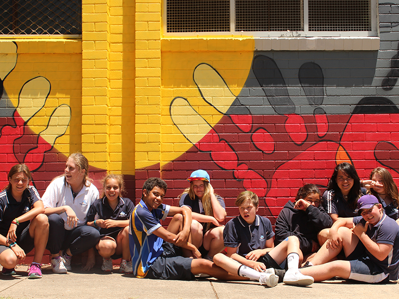 Messengers participants pose in front of Kippax mural