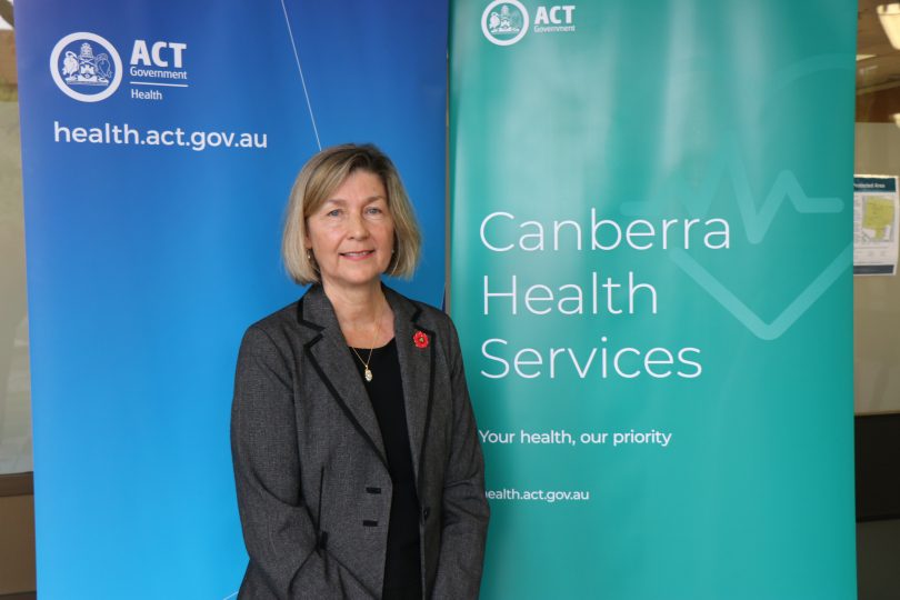 Dr Elizabeth Moore posing in front of ACT Government banners.