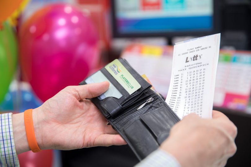 Man holding Lotto ticket and wallet