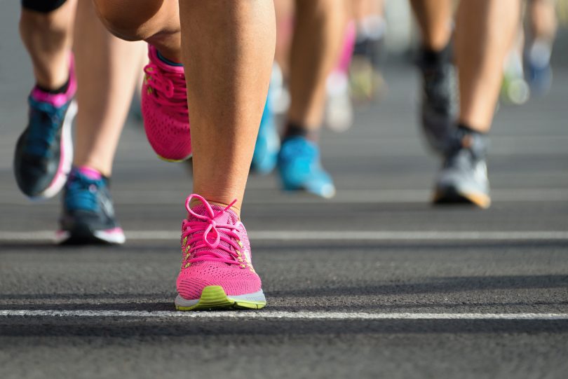 Close-up of runners' feet on city road.