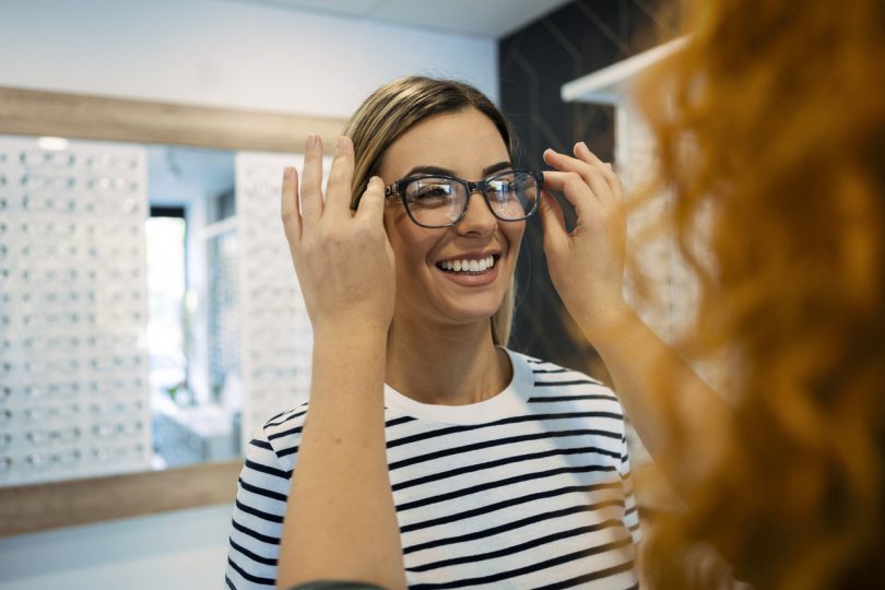 a woman trying on glasses