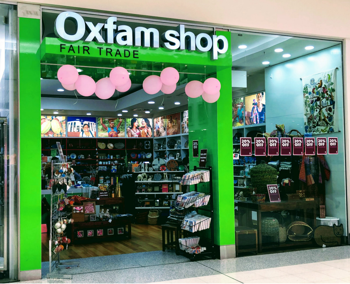 Oxfam shopfront in the Canberra Centre with pink balloons in doorway and sale signs in window