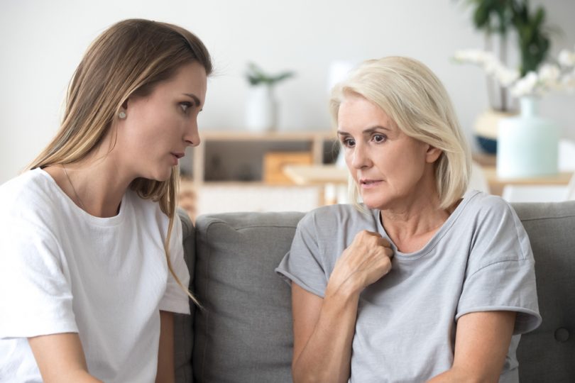 Mother and daughter in conversation on couch.