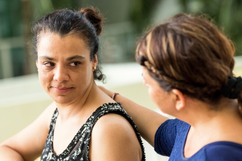 Sad woman being comforted by friend.