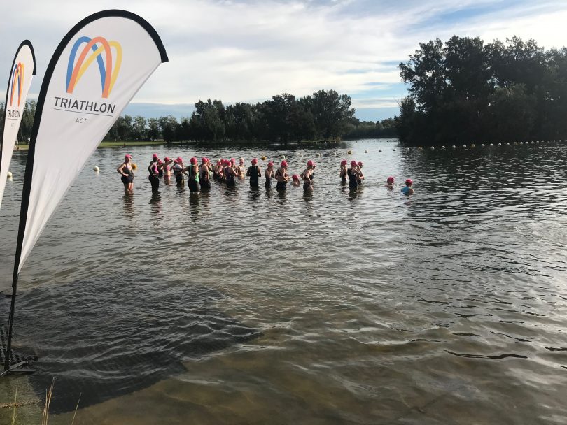 Competitors in water at triathlon in ACT