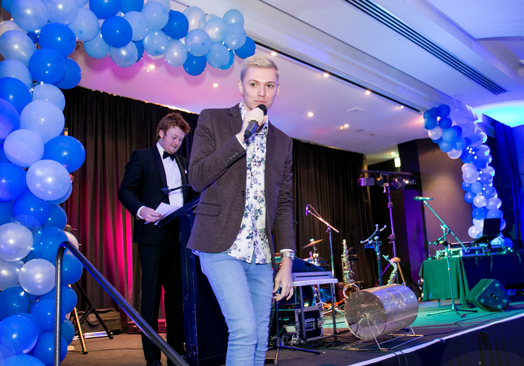 Johnathan Davis descending stairs from a stage with a microphone in hand