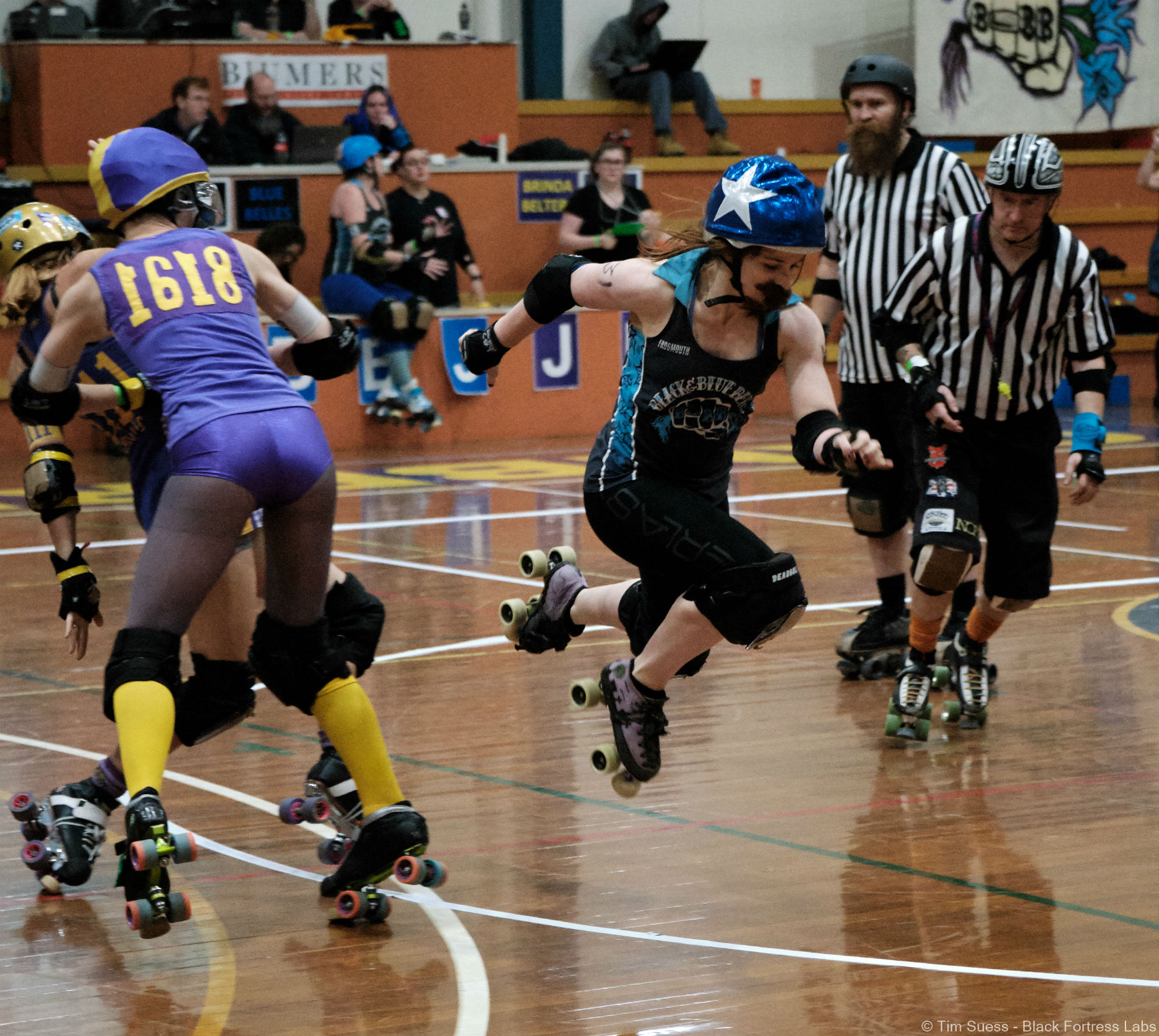 Black and Blue Belles jammer in mid-air while the Brindabelters blockers are behind her