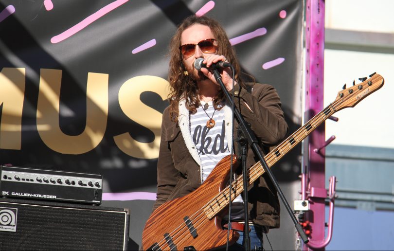 Hands Like Houses bassist Joel Tyrell talking into microphone onstage.